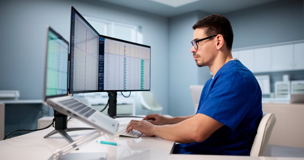 Hispanic Doctor Using Spreadsheet To Manage Medical Billing Data Efficiently