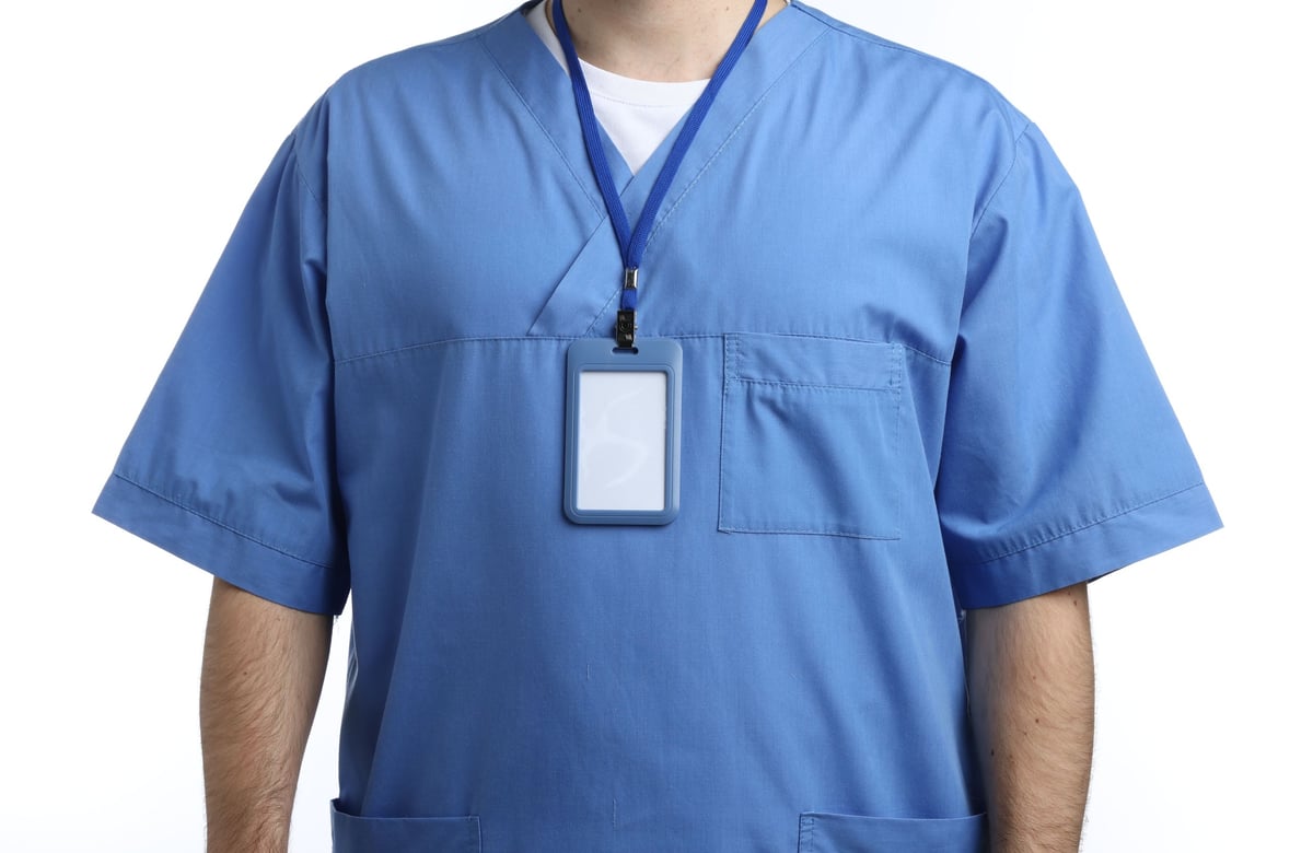 Medical worker with blank badge on white background, closeup